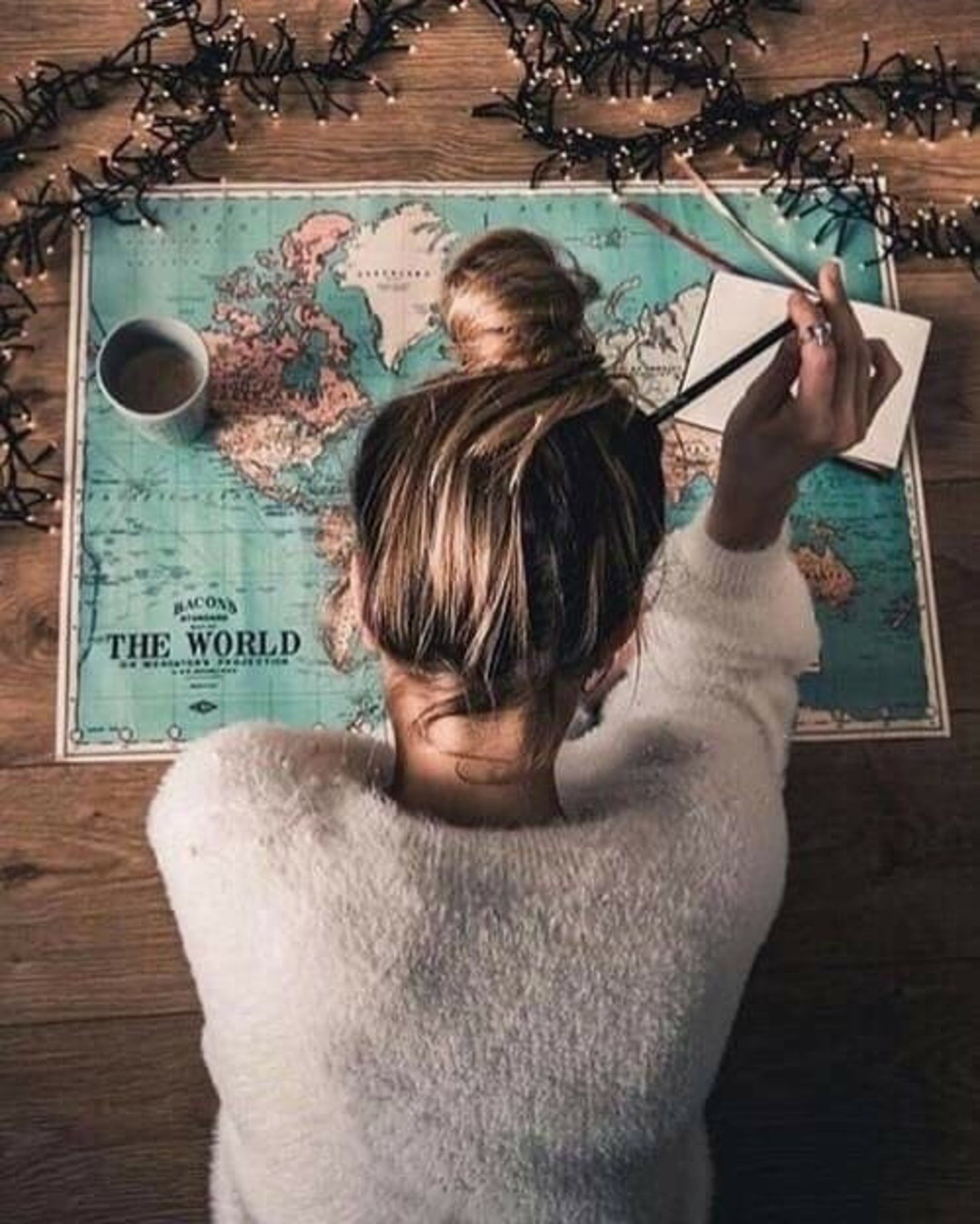 femme carte du monde et stylo dans les cheveux