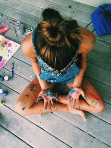 Femme assise avec peinture sur les mains